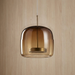 Whisky toned glass shade and knurled brass connector against a warm wood grain wall, BO-HA Astrid