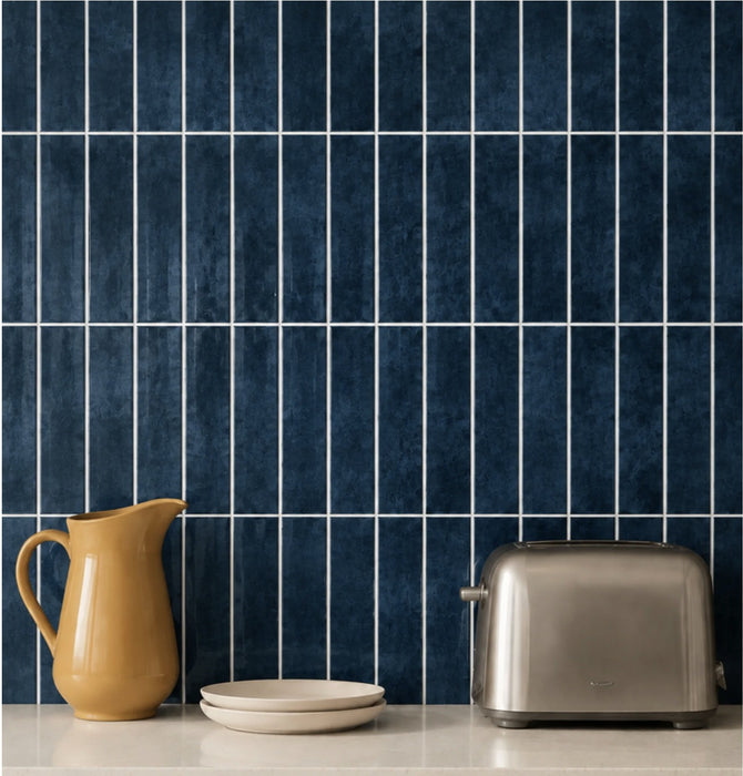 Ebba peel and stick backsplash in Lakewater Blue behind a kitchen counter with a mustard jug and a toaster