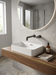 Grifo de baño de pared sobre un lavabo de sobreponer: Idun gris cepillado sobre una balda de nogal
